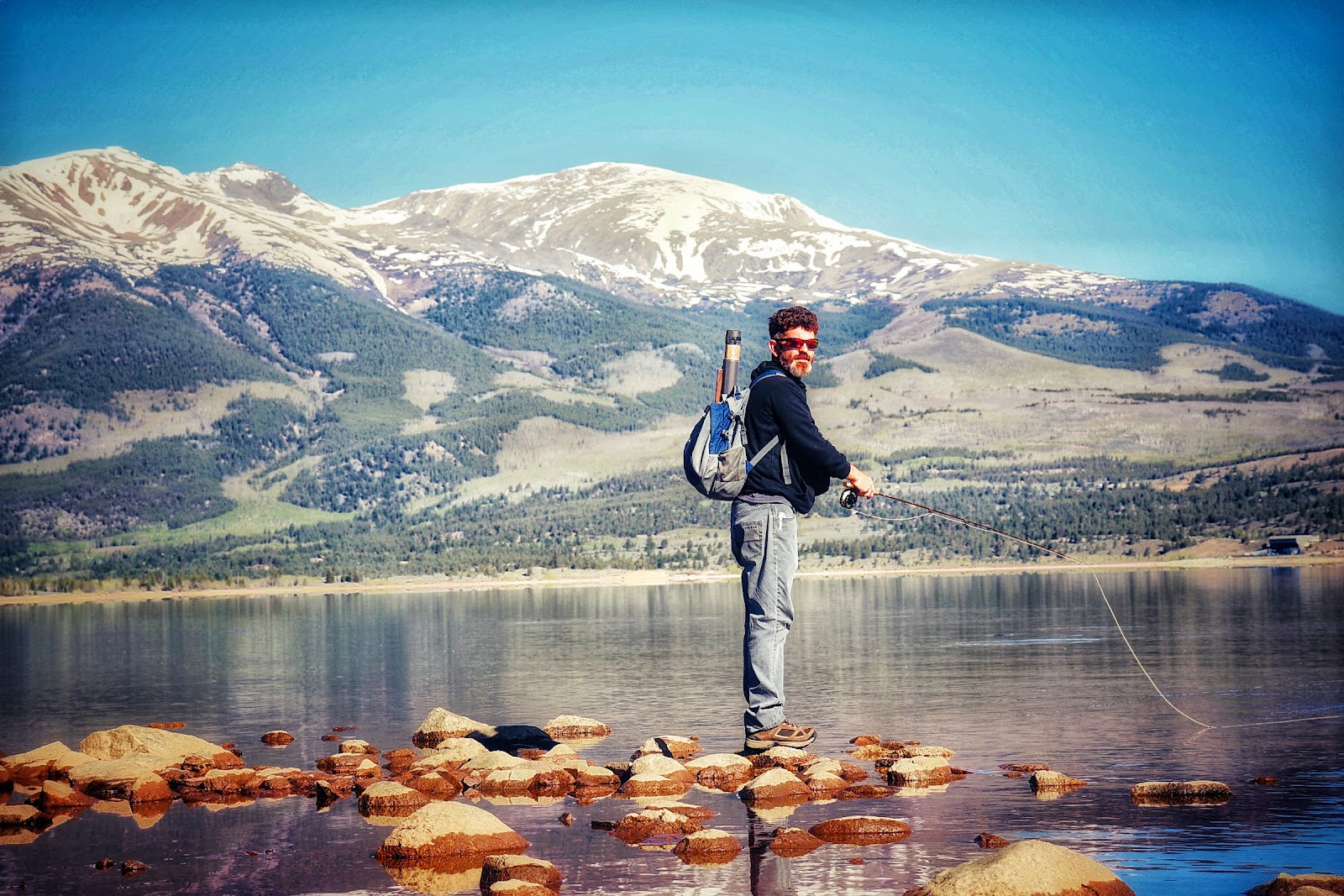 A man fishing in the mountains.